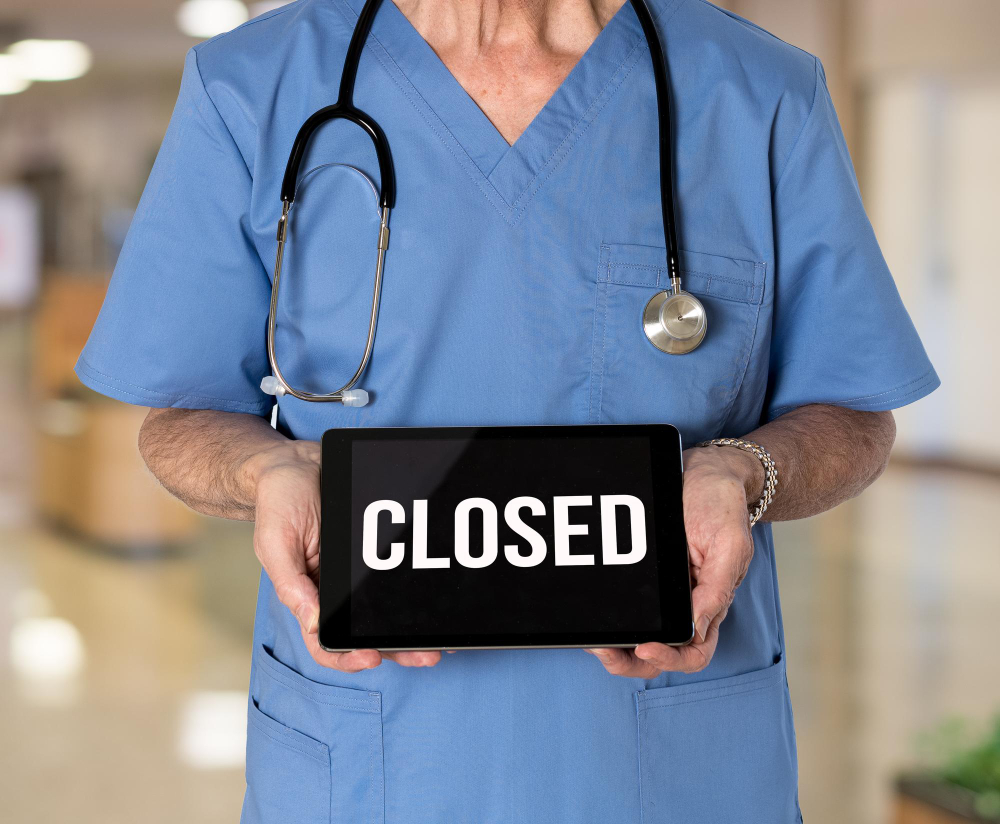 Doctor holding Closed sign