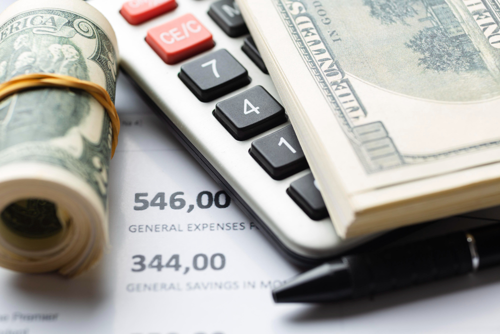 Cash on top of a calculator on top of a line sheet
