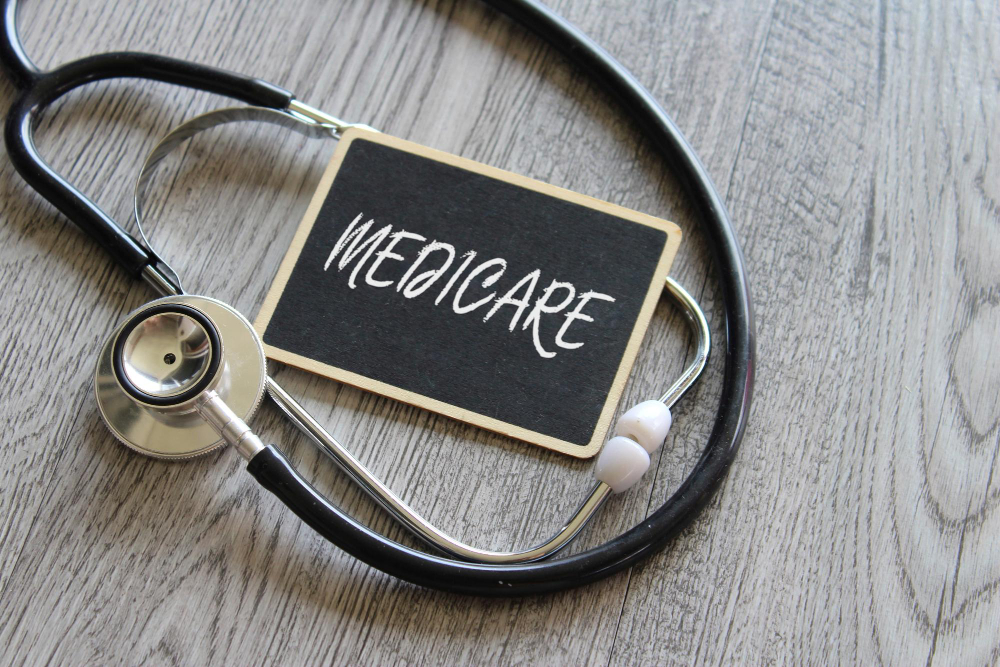A Stethoscope around a small chalked sign with Medicare written on it.