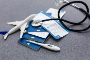 stethoscope with toy plane, thermometer, and plane tickets